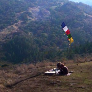 Person at prayer flags overlooking mountain valley at Heartwood Institute massage school